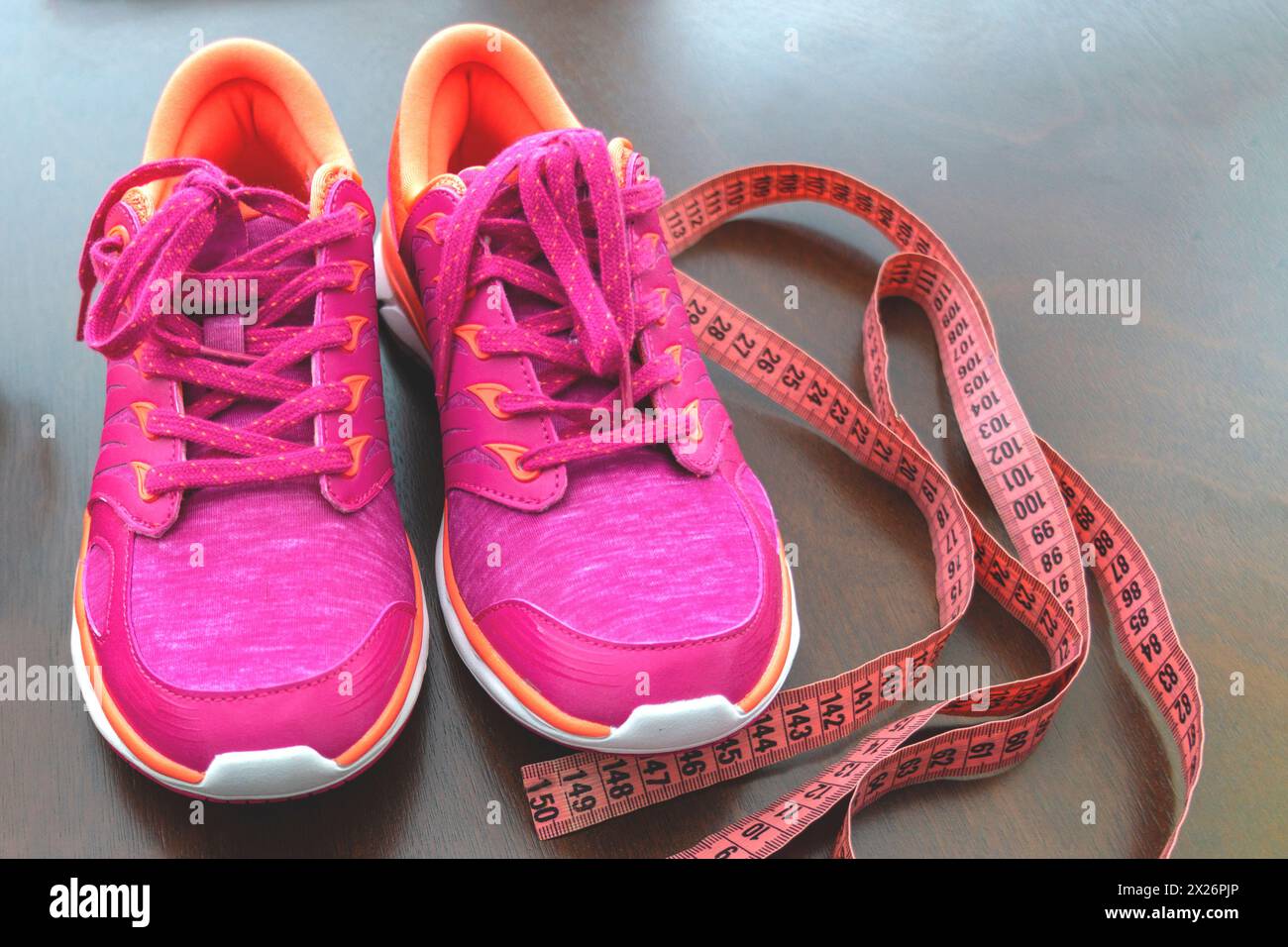 Close up. meter tape, pink sneakers. Concept Healthy way of life. Fitness accessories.The concept of sport. sneakers on background. The first step to Stock Photo