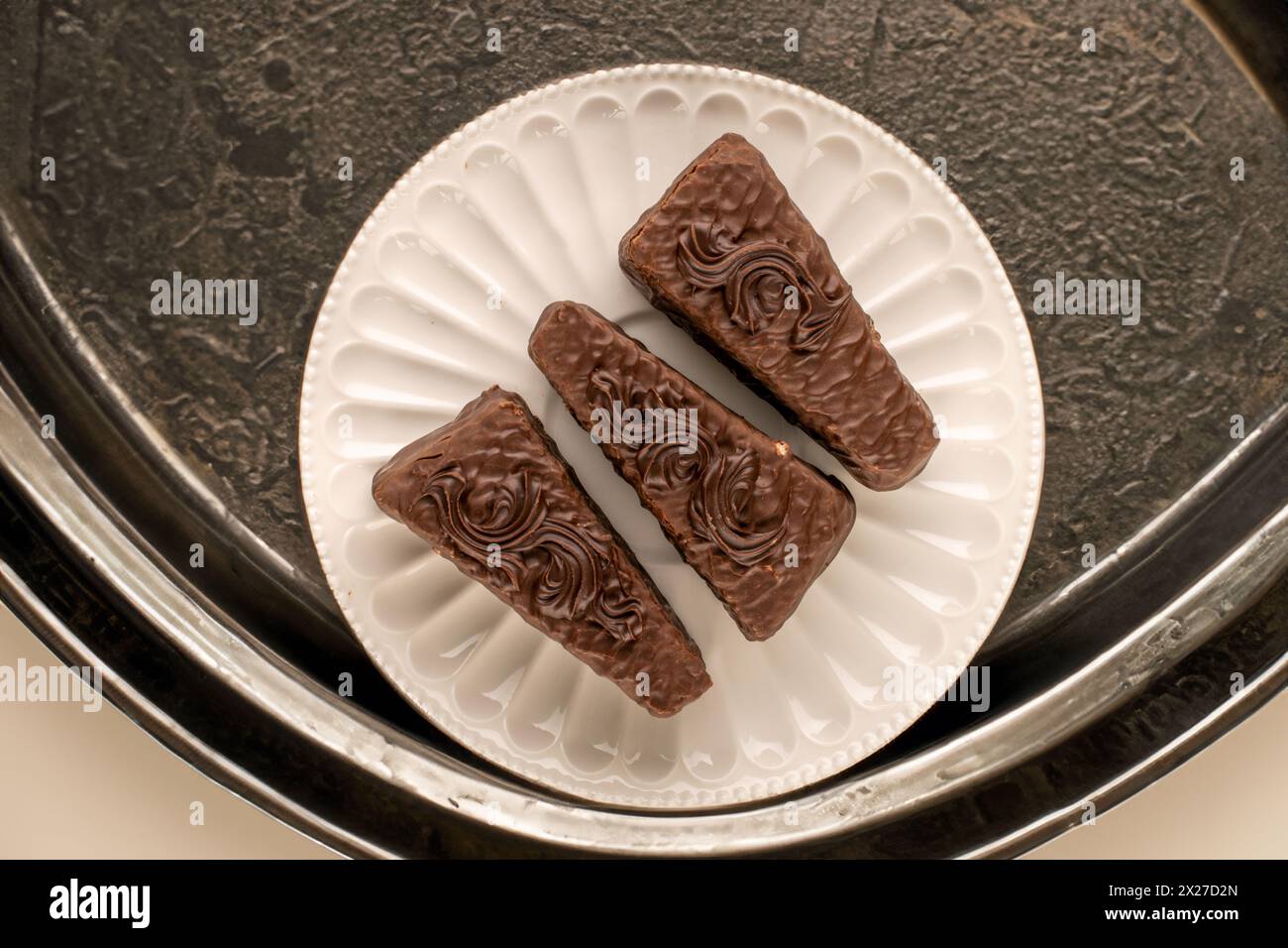 Three pieces of chocolate waffle cake with ceramic plate on iron table, top view Stock Photo