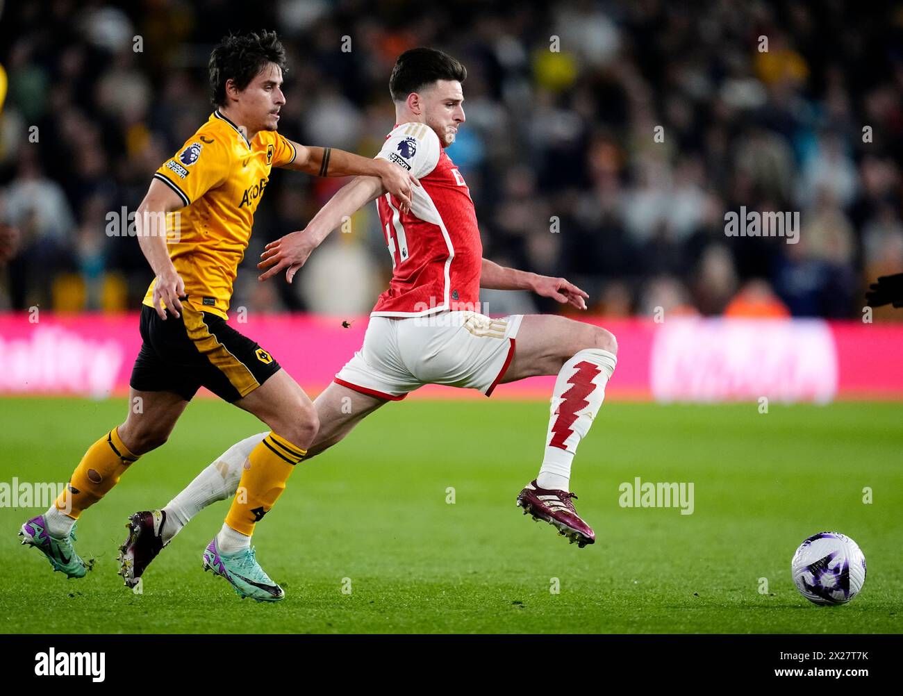Arsenal's Declan Rice and Wolverhampton Wanderers' Hugo Bueno (left) during the Premier League match at Molineux Stadium, Wolverhampton. Picture date: Saturday April 20, 2024. Stock Photo