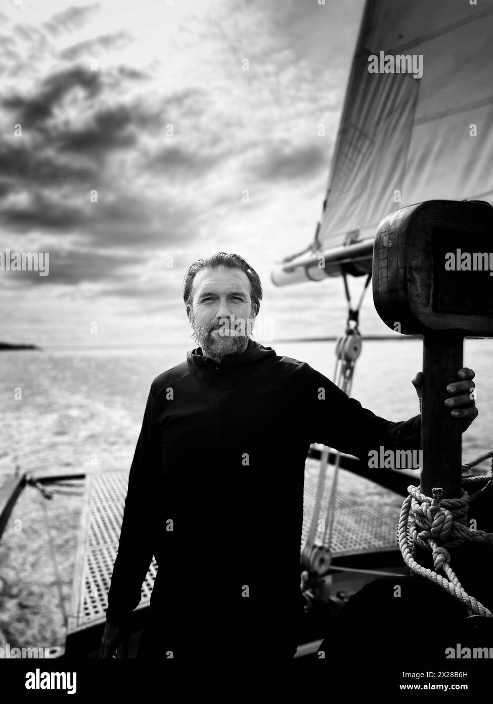 Half-length portrait of bearded mid-adult man standing on sailboat Stock Photo