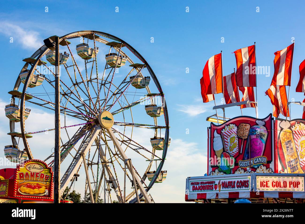 A Ferris Wheel can be seen beyond the junk food vendors at the Allen County Fairgrounds in Fort Wayne, Indiana, USA. Stock Photo