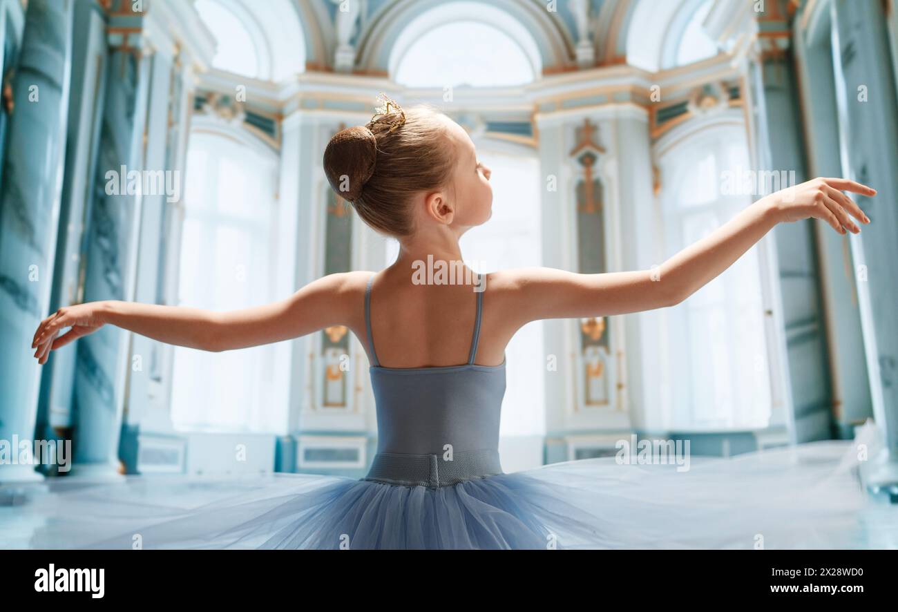 Cute little girl dreaming of becoming a ballerina. Child girl in a tutu dancing in the ball room. Baby girl is studying ballet. Stock Photo