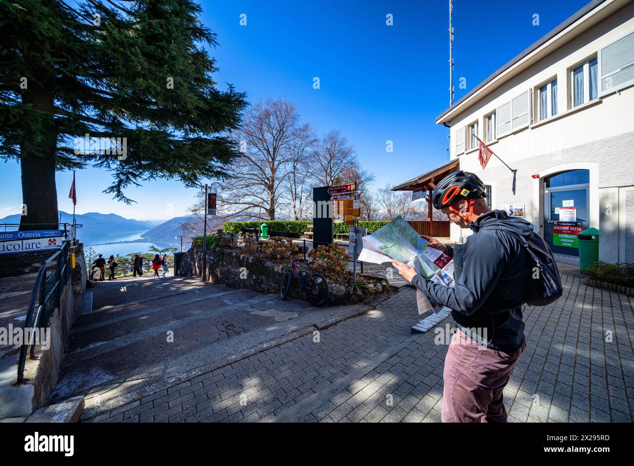 Studying the map at the top of Monte Brè before starting mountain biking, at Lugano, Switzerland Stock Photo