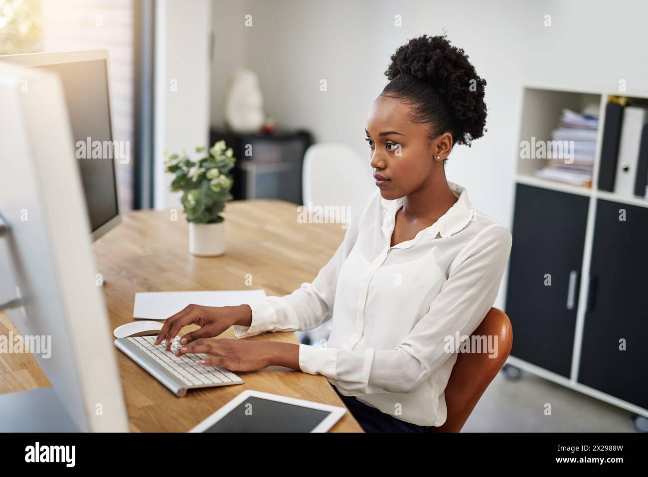 Business woman, computer and reading in office for information technology, software or online programming. African programmer or web developer typing Stock Photo