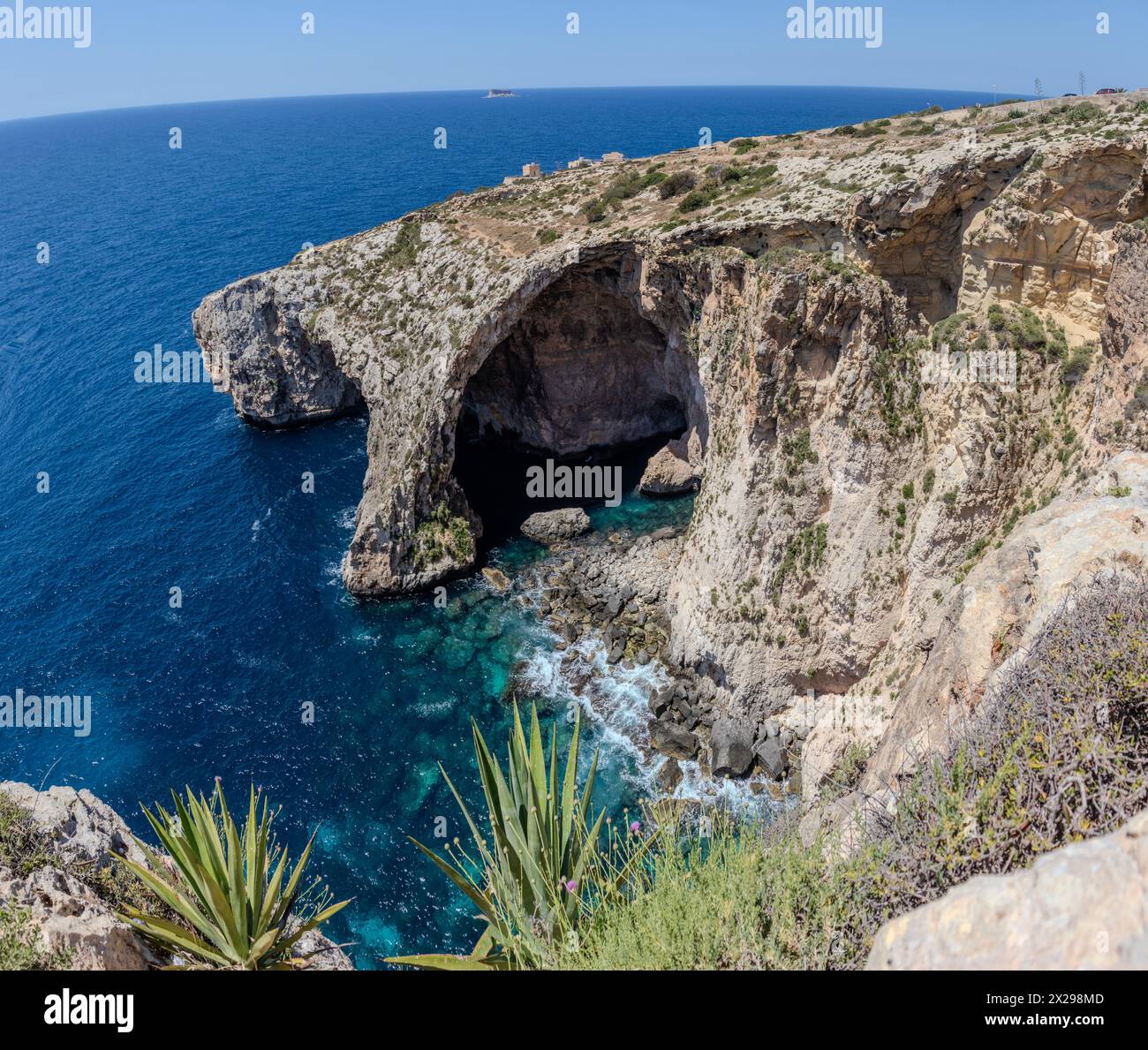 A cliff on the ocean shore with a cave and natural arch Stock Photo - Alamy