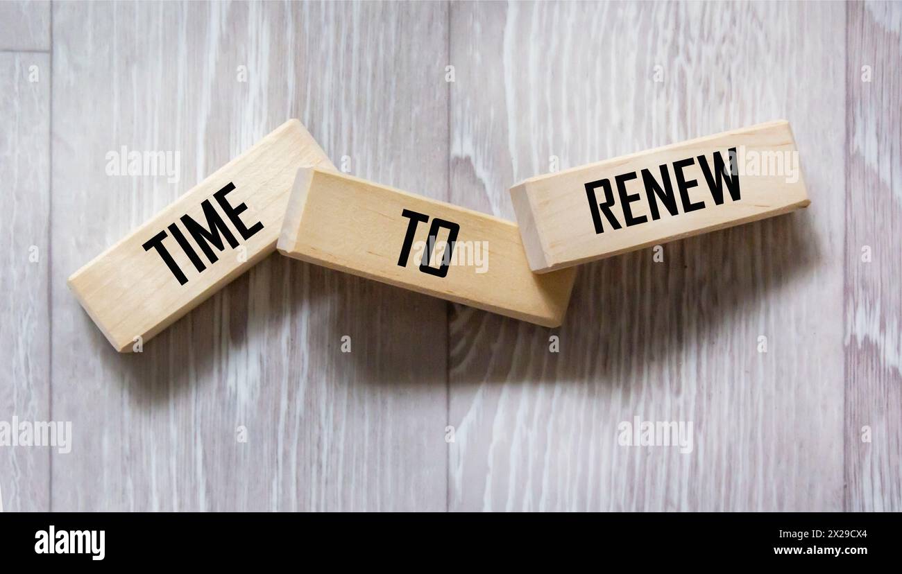 The word RENEWAL TIME is written on wooden blocks on a gray table. Stock Photo