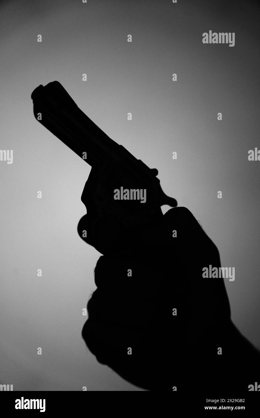 Man spy detective holding pistol gun book cover design artistic photo black and white ighting. Stock Photo