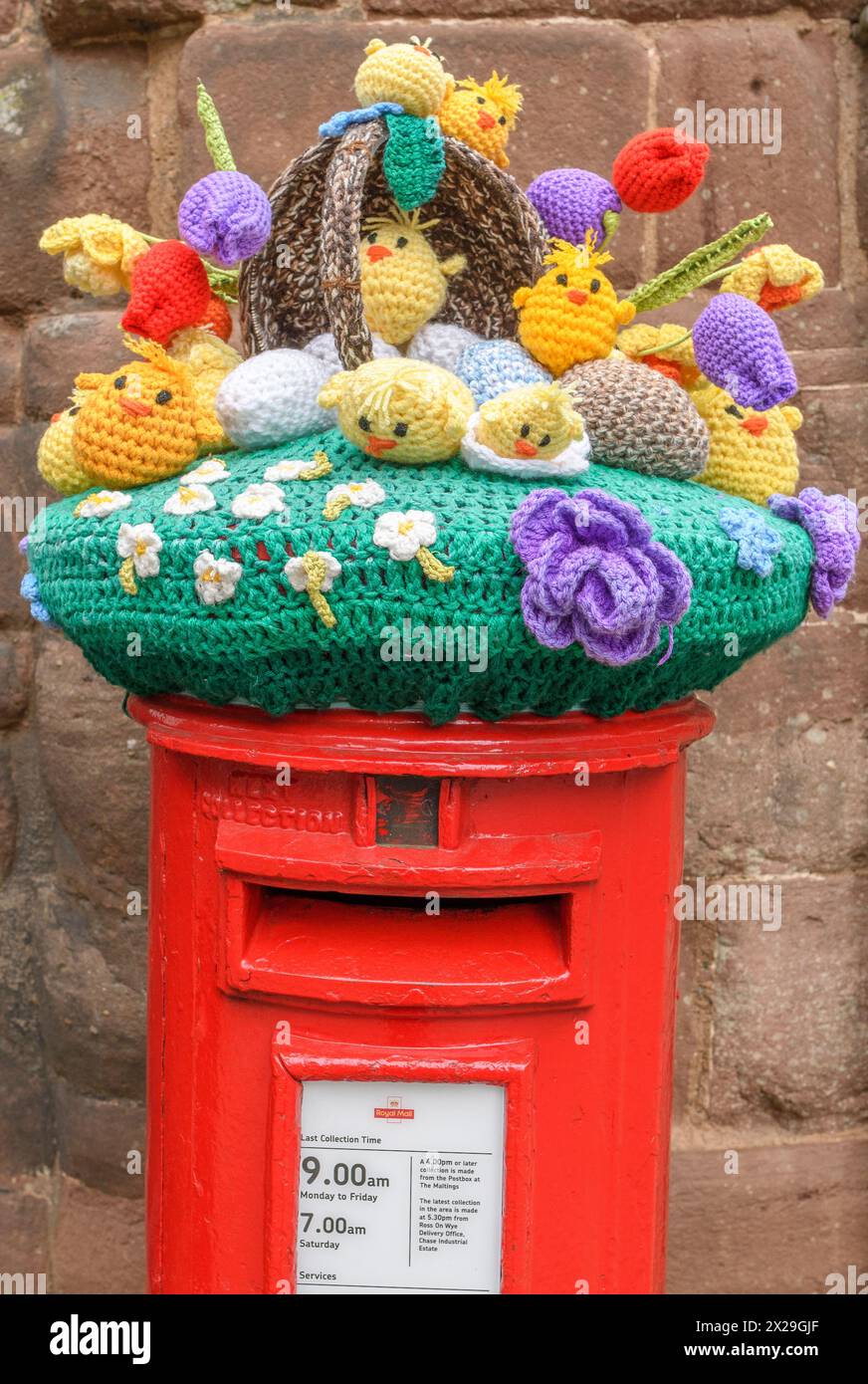 Knitted Easter bonnet on a Royal Mail post box, Ross-on-Wye, Herefordshire, UK Stock Photo