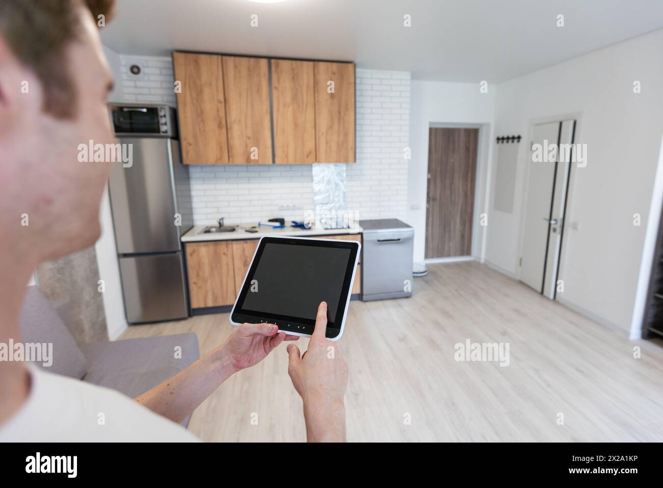 Worker with tablet computer checking alarm system indoors. Stock Photo
