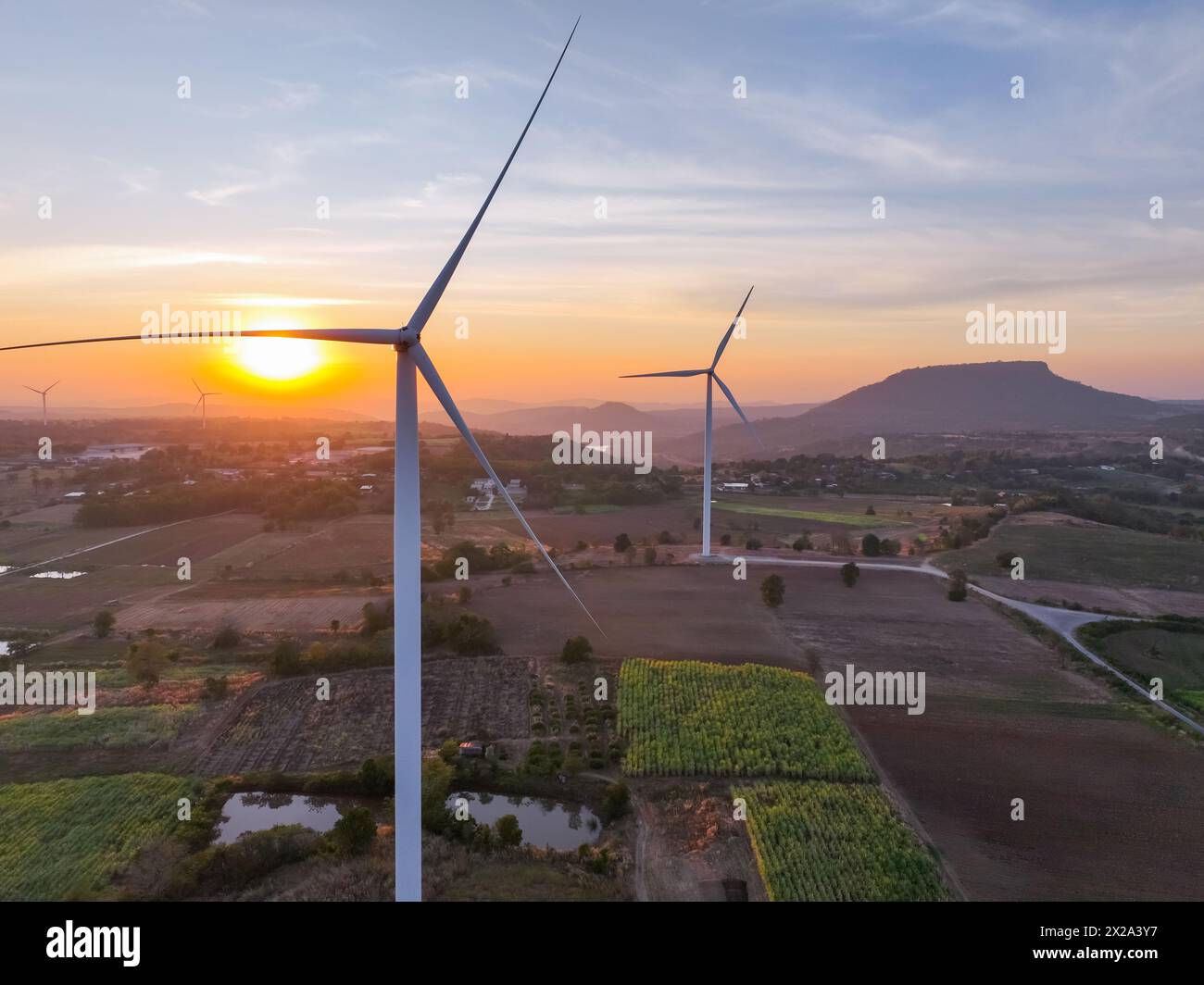 Wind farm field and sunset sky. Wind power. Sustainable, renewable energy. Wind turbines generate electricity. Sustainable development. Green tech Stock Photo