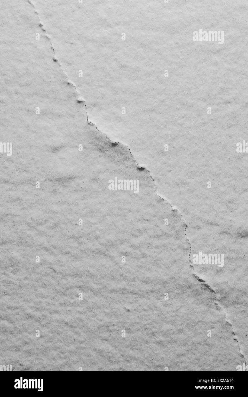 A closeup of a crack in a plaster wall as a background. Stock Photo