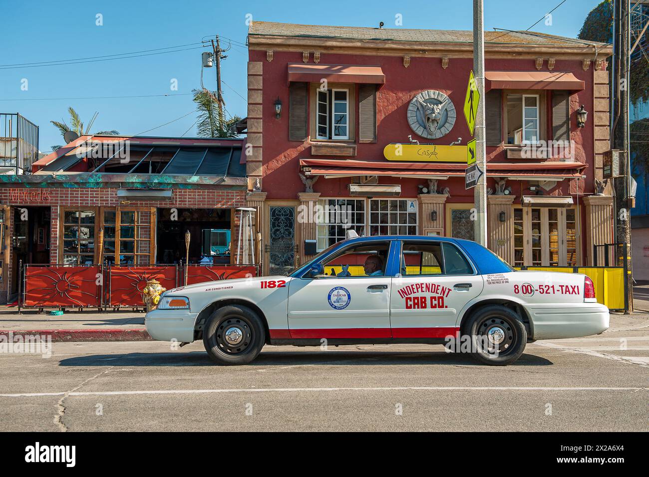 Cab driving past a restaurant in iconic Venice Beach on the pacific coast beach in Venice, Los Angeles, CA, USA Stock Photo