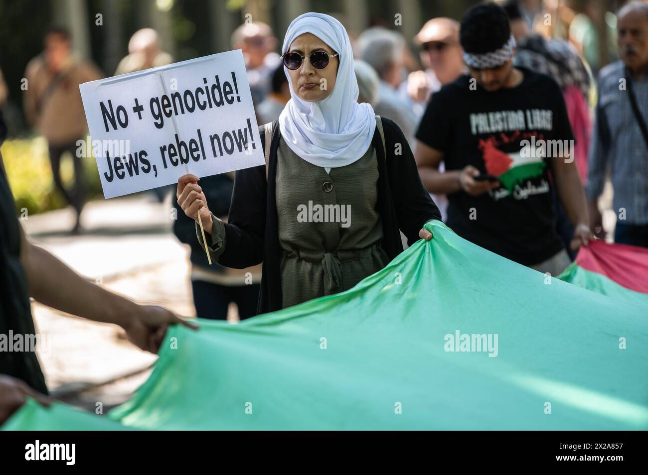 Madrid, Spain. 21st Apr, 2024. A woman holds a Palestinian flag during a demonstration in support of the Palestinian people. Thousands of people rally in Madrid under the slogan 'stop genocide in Palestine' demanding the end of arms trade with Israel and a definitive ceasefire in the Gaza Strip. Credit: Marcos del Mazo/Alamy Live News Stock Photo