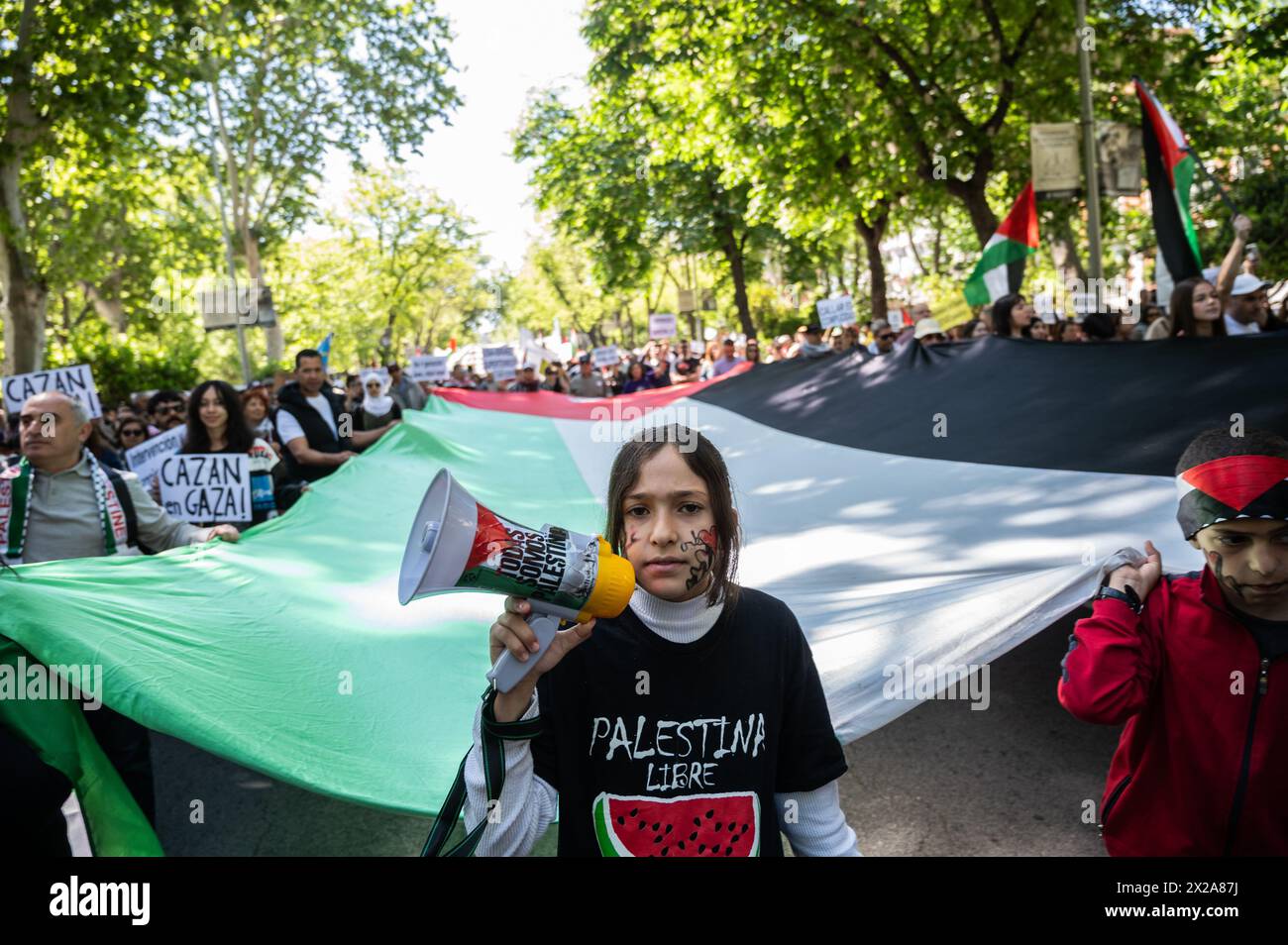 Madrid, Spain. 21st Apr, 2024. People carrying a large Palestinian flag during a demonstration in support of the Palestinian people. Thousands of people rally in Madrid under the slogan 'stop genocide in Palestine' demanding the end of arms trade with Israel and a definitive ceasefire in the Gaza Strip. Credit: Marcos del Mazo/Alamy Live News Stock Photo