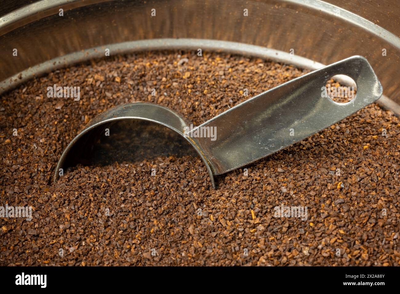 Medium roast coffee grounds with a scoop in a metal coffee can. Stock Photo