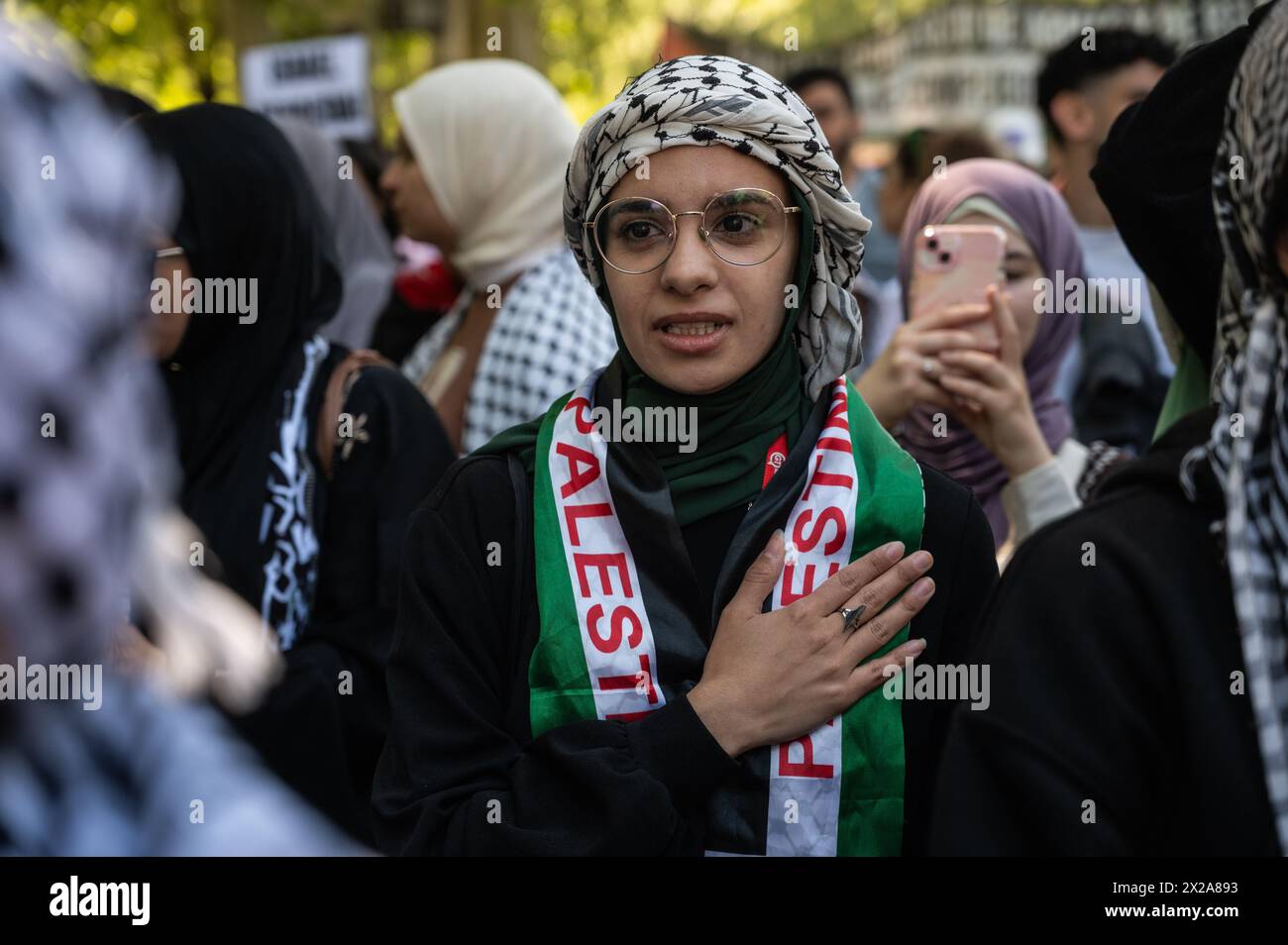 Madrid, Spain. 21st Apr, 2024. A woman places her hand on her heart during a demonstration in support of the Palestinian people. Thousands of people rally in Madrid under the slogan 'stop genocide in Palestine' demanding the end of arms trade with Israel and a definitive ceasefire in the Gaza Strip. Credit: Marcos del Mazo/Alamy Live News Stock Photo