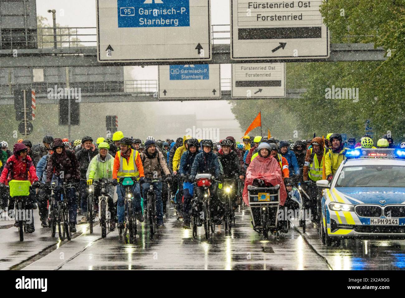 Rad-Sternfahrt des ADFC, Teilstück über die Autobahn A95, München, 21. April 2024 Deutschland, München, 21. April 2024, große Rad-Sternfahrt des ADFC, hier bei Schneefall auf der gesperrten Autobahn A 95 München-Garmisch bei München-Sendling, alle in Regenjacken eingehüllt und durchnässt, fahren stadteinwärts Richtung Luise-Kiesselbach-Platz, kehren um und fahren auf der Gegenseite zurück Richtung Ausfahrt Kreuzhof, Fahrraddemo für die bessere Umsetzung des Radentscheids München , tausende Teilnehmer, Fahrrad-Demo, gemeinsam Radeln für eine bessere Radinfrastruktur, Teilstück über die A95, Ver Stock Photo