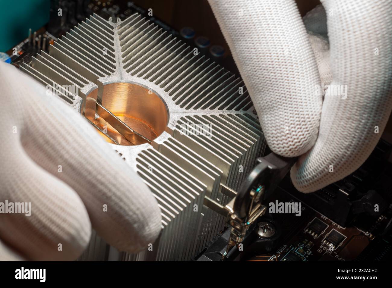 Aluminum cooling radiator with copper core mounted with a clamp by skilled service staff on the computer processor Stock Photo