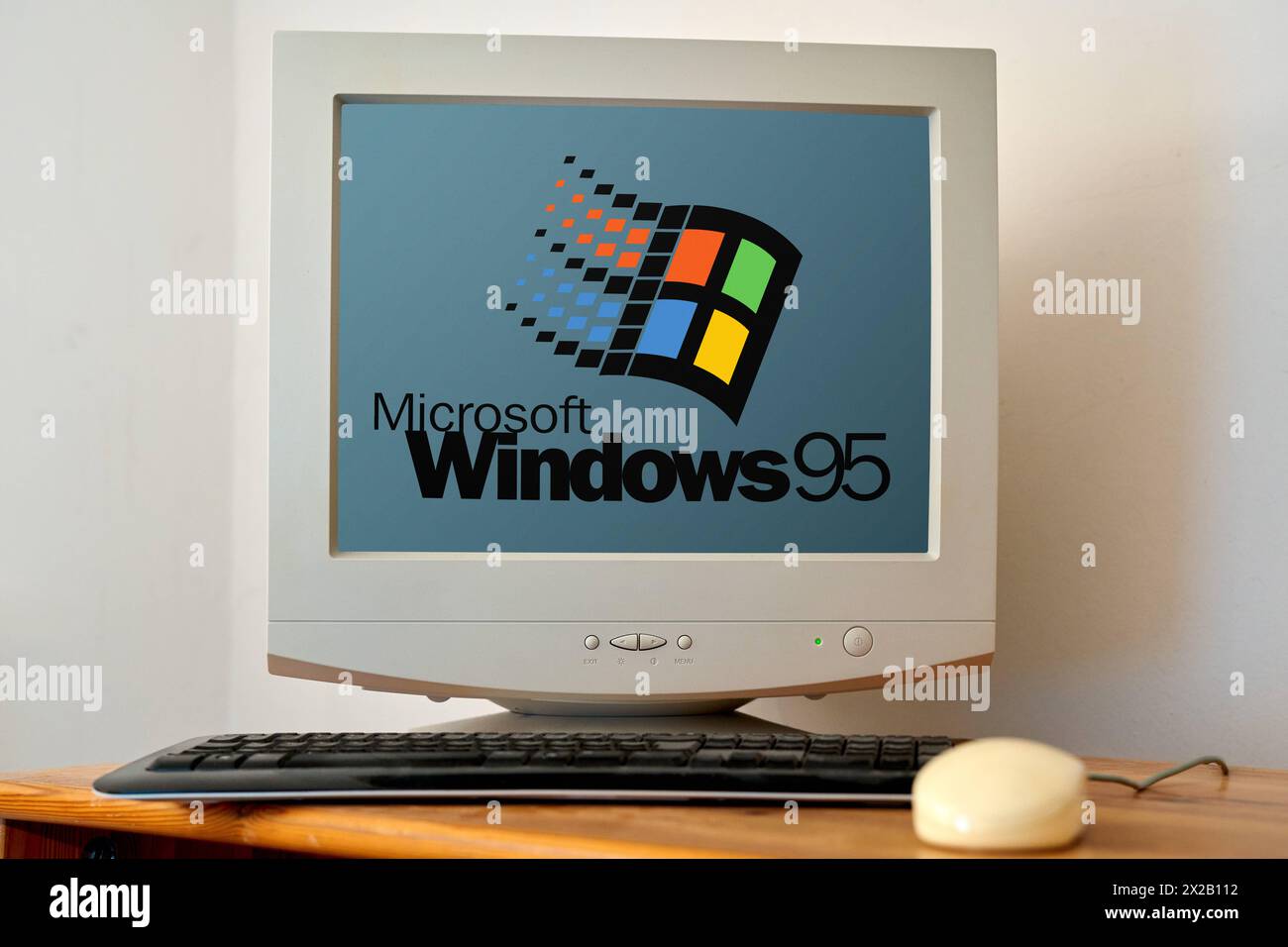 April 21, 2024: Old computer on a desk with a screen showing the Microsoft Windows 95 logo. PHOTOMONTAGE *** Alter Computer auf einem Schreibtisch mit Bildschirm auf dem das Microsoft Windows 95 Logo zu sehen ist. FOTOMONTAGE Stock Photo