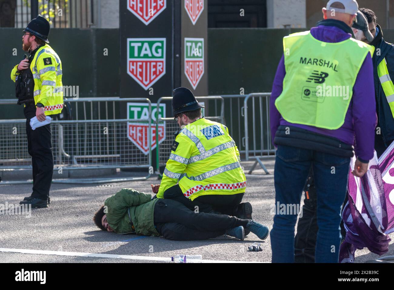 Tower Hill, London, UK. 21st Apr, 2024. Police detained a male for forcing his way onto the closed road section of the route of the London Marathon, pushing his way past marshals Stock Photo