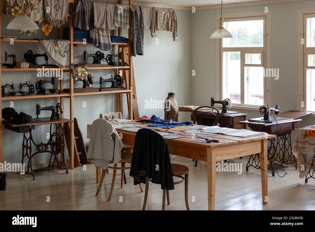 Interior with sewing accessories. Antique sewing machines, clothes for viewing. Stock Photo