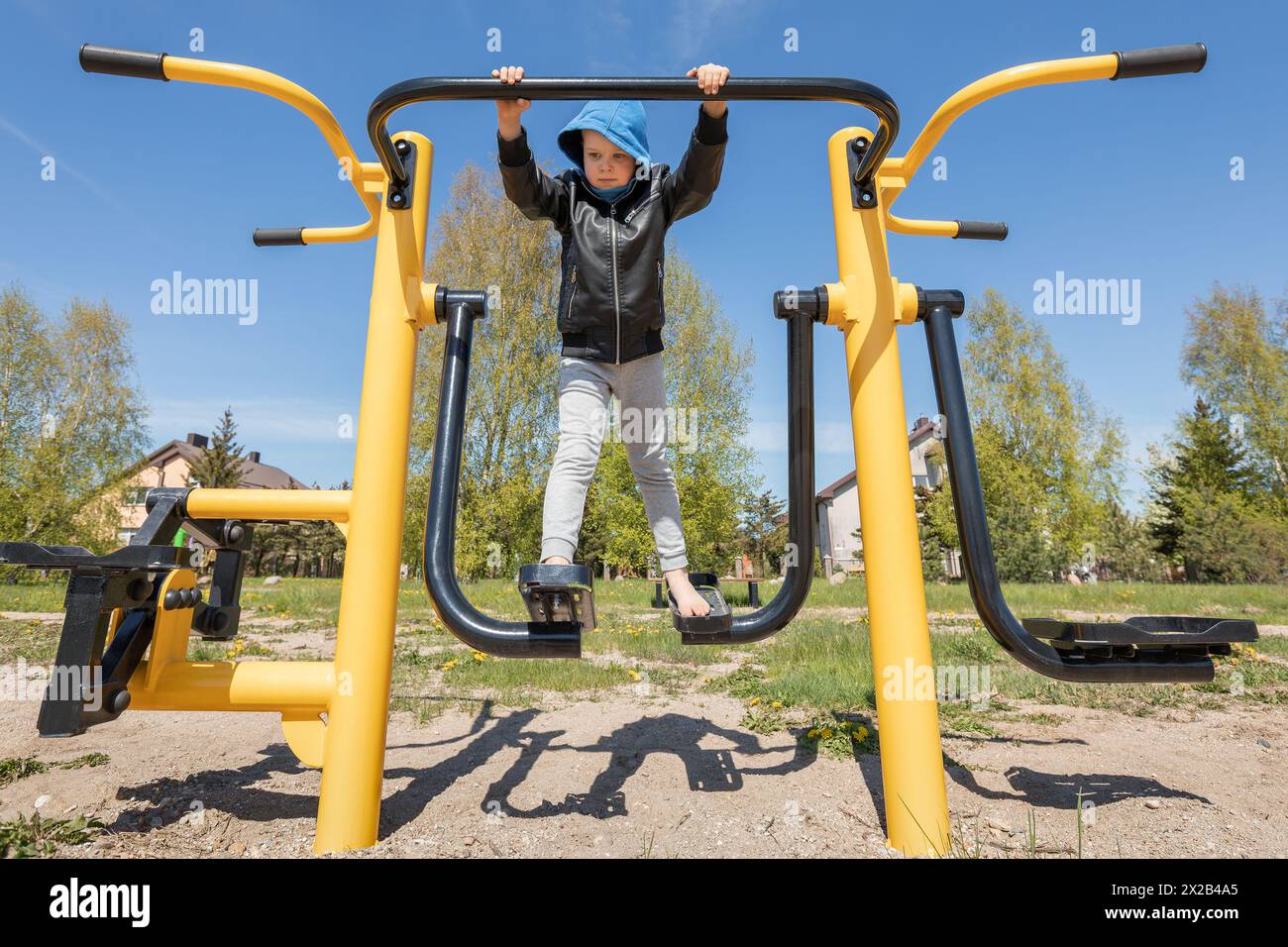 A little boy is exercising in a city park on an air walker. Stock Photo