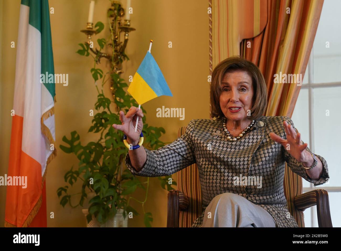 Former Speaker of the United States House of Representatives Nancy Pelosi holds a Ukrainian flag during a fireside chat with US Ambassador to Ireland Claire Cronin at the Ambassador's residence, Phoenix Park, Dublin. Issue date: Sunday April 21, 2024. Stock Photo