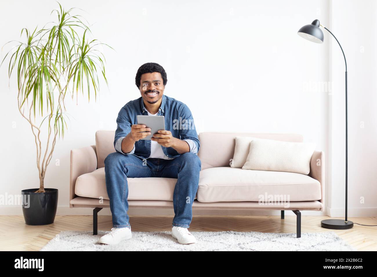 Man smiling while using digital tablet at home Stock Photo