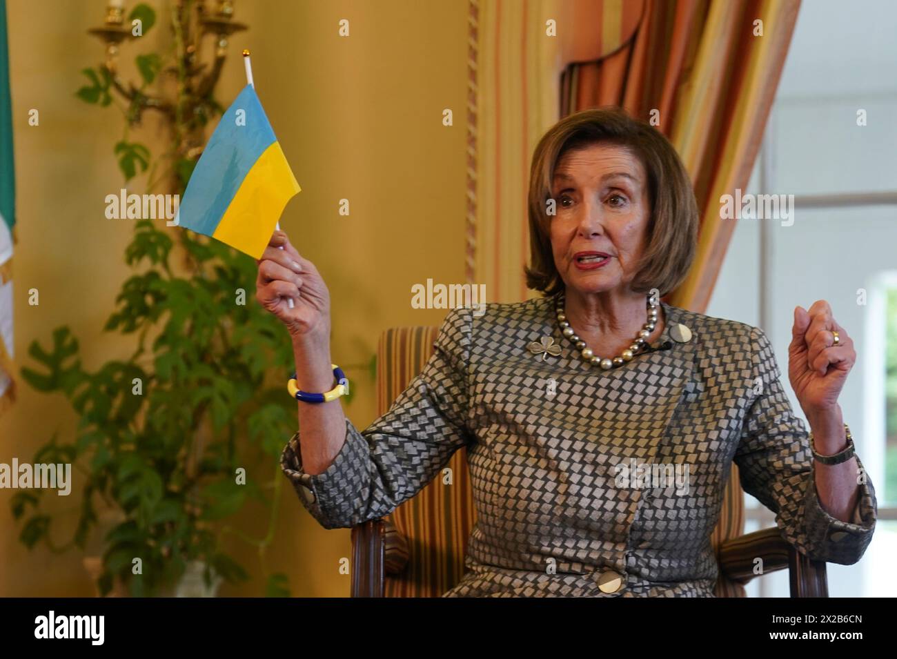 Former Speaker of the United States House of Representatives Nancy Pelosi holds a Ukrainian flag during a fireside chat with US Ambassador to Ireland Claire Cronin at the Ambassador's residence, Phoenix Park, Dublin. Issue date: Sunday April 21, 2024. Stock Photo