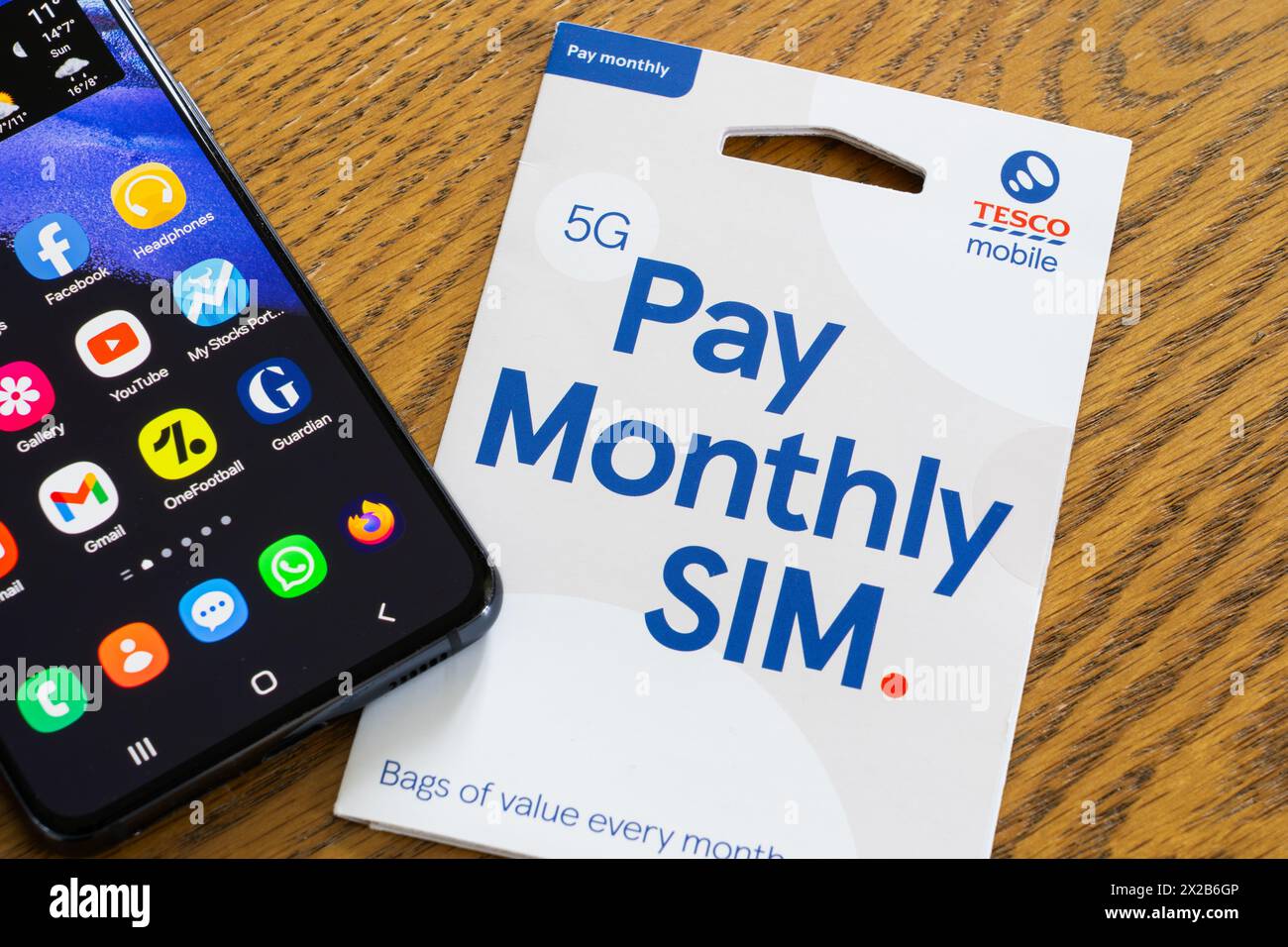 Tesco Mobile 5G pay monthly SIM pack with a replacement SIM card, the Tesco Mobile logo and a smartphone, England. Concept: supermarket mobile network Stock Photo