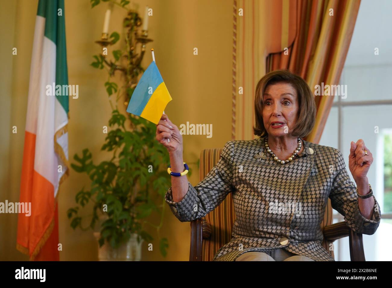 Former Speaker of the United States House of Representatives Nancy Pelosi holds a Ukrainian flag during a fireside chat with US Ambassador to Ireland Claire Cronin at the Ambassador's residence, Phoenix Park, Dublin. Issue date: Sunday April 21, 2024. Stock Photo