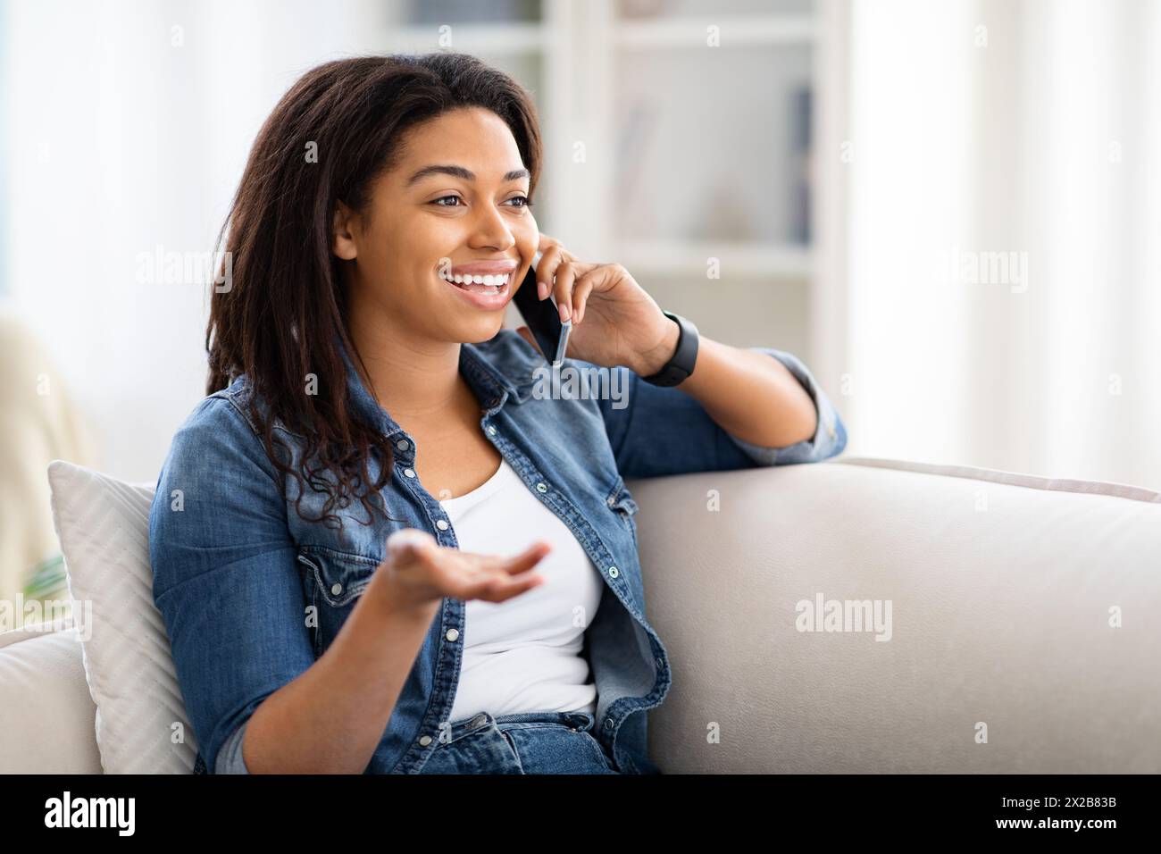 Woman Sitting on Couch Talking on Cell Phone Stock Photo