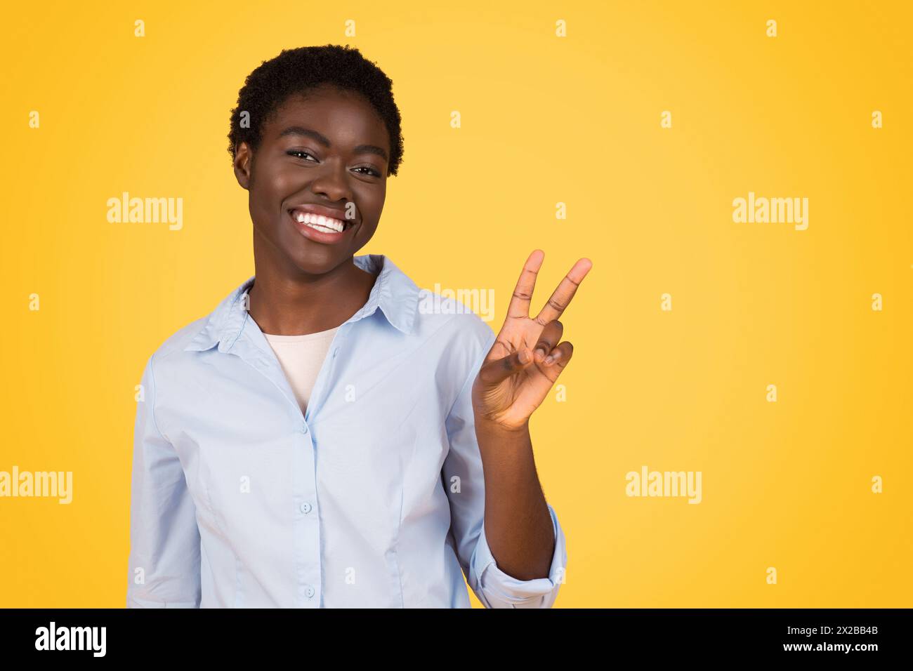 Cheerful zoomer african american woman making peace sign Stock Photo ...