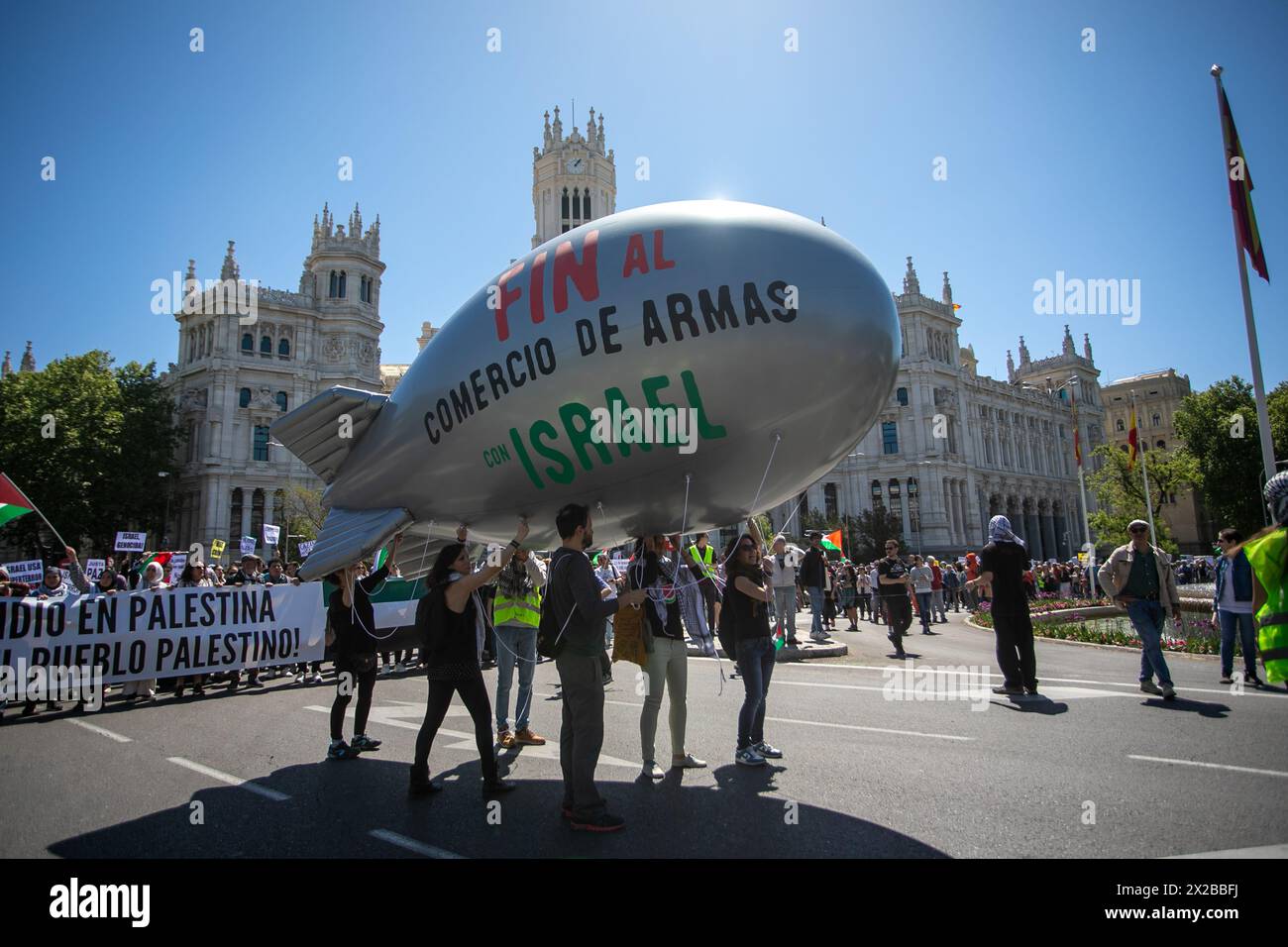 Madrid, Spain. 21st Apr, 2024. A group of protesters carry a Zeppelin balloon with the slogan: 'End the arms trade with Israel' as they pass by the Cibeles Palace during a pro-Palestinian demonstration. The Solidarity Network against the Occupation of Palestine (RESCOP) together with other pro-Palestinian organizations demonstrated on the streets of Madrid to ask the Spanish Government of Pedro Sánchez to “End the arms trade and relations with Israel.” of “Enough of the complicity of the Government and companies” with the state of Israel. Credit: SOPA Images Limited/Alamy Live News Stock Photo