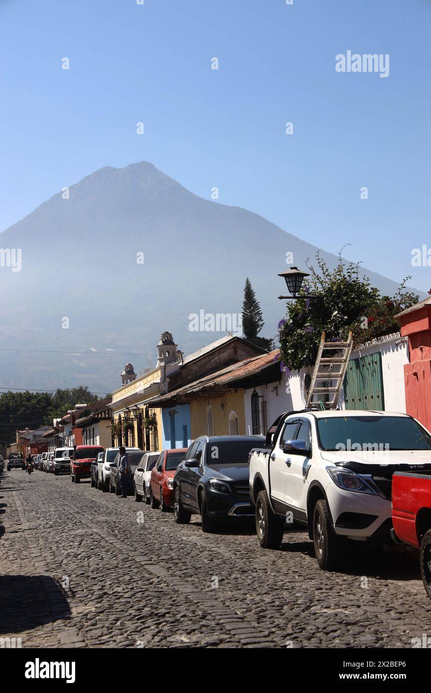 Antigua, old capital of Guatemala. Street scene, one of a series.Colourful buildings of Central America.In the background is Volcano Agua.Volcan Agua. Stock Photo