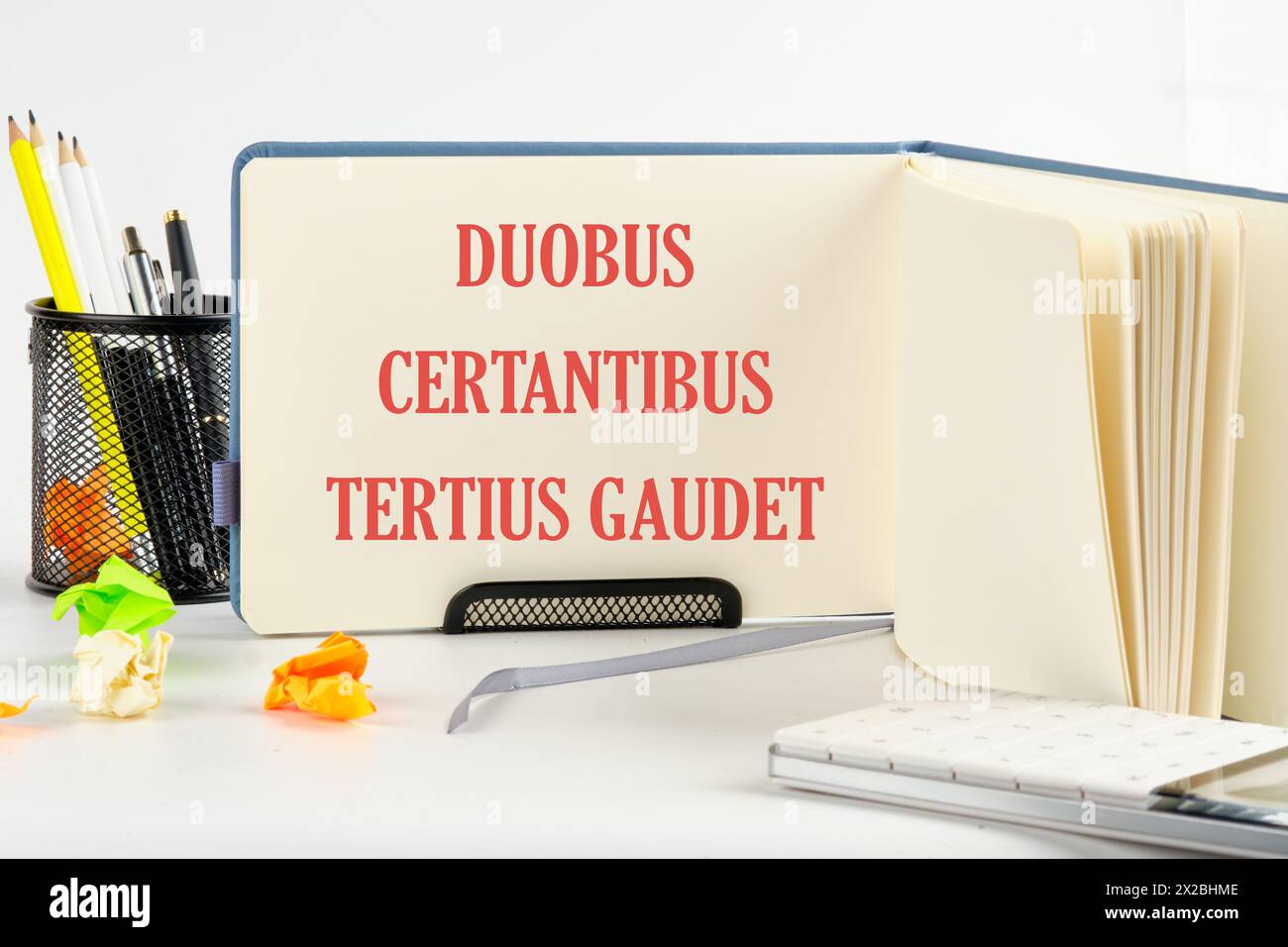 DUOBUS CERTANTIBUS TERTIUS GAUDET it means in Latin While two argue, the third rejoices. on a blank sheet of an open business notebook Stock Photo