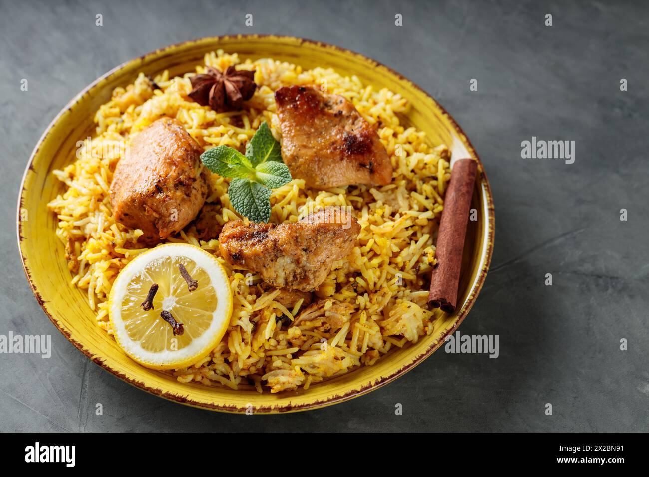 Chicken Biryani with Basmati Rice on Yellow Plate, Popular Indian and Pakistani Food, Closeup