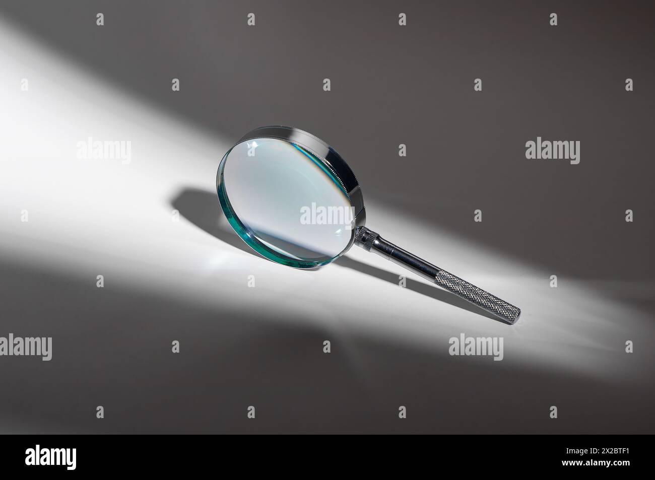 Abstract exploration of light and shadow. Silver metal glass magnifier lens  zooms in on mystery. Investigate, analyze, seek. Optical tool for scientif  Stock Photo - Alamy, image size:1300x953