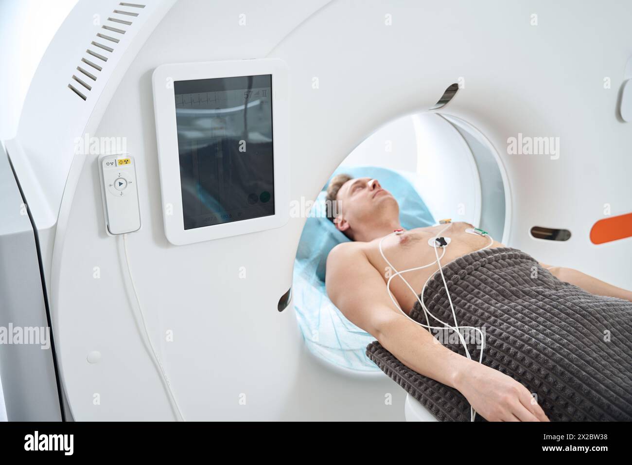 Man is undergoing ECG-gated coronary computed tomography angiography Stock Photo