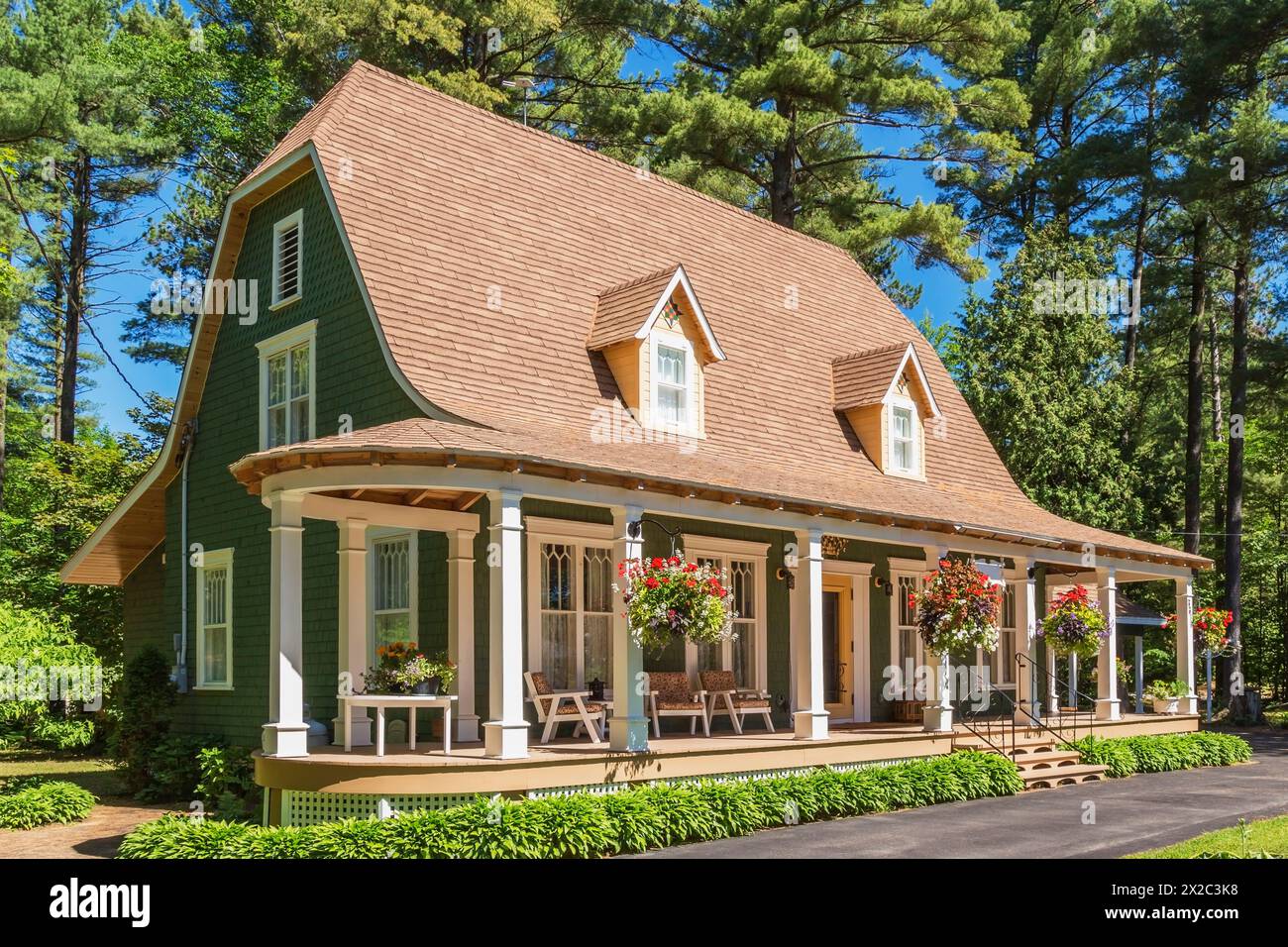 Old 1920s green cedar wood shingles siding with white trim bell roof style  house facade in summer Stock Photo - Alamy, image size:1300x956