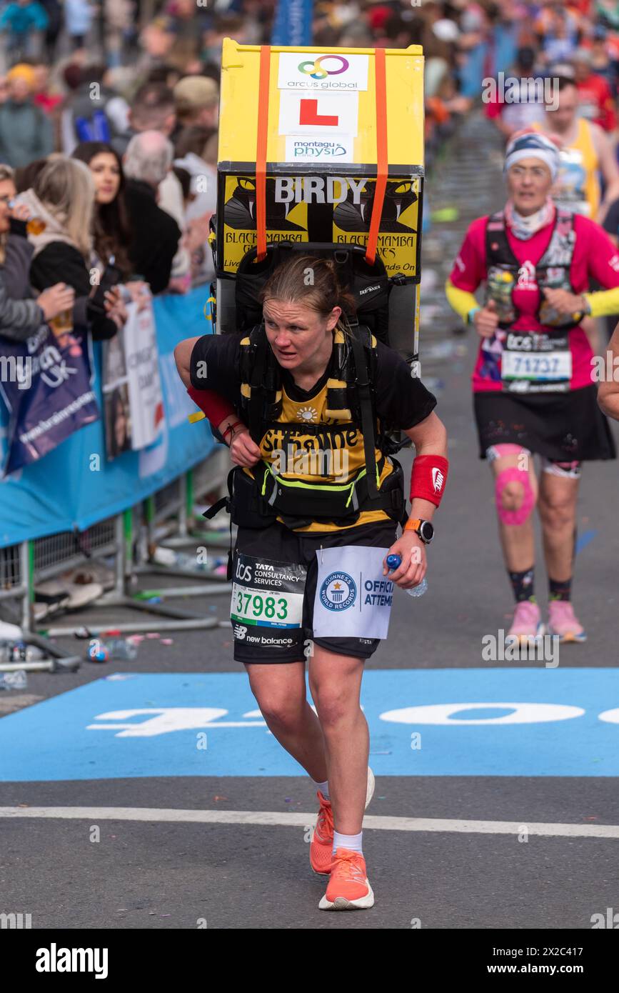 Laura Bird competing in the TCS London Marathon 2024 passing through Tower Hill, London, UK. Carrying a household appliance, fridge Stock Photo