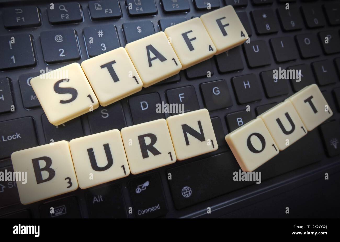 Staff burn out, in Scrabble letters & words on a computer keyboard Stock Photo