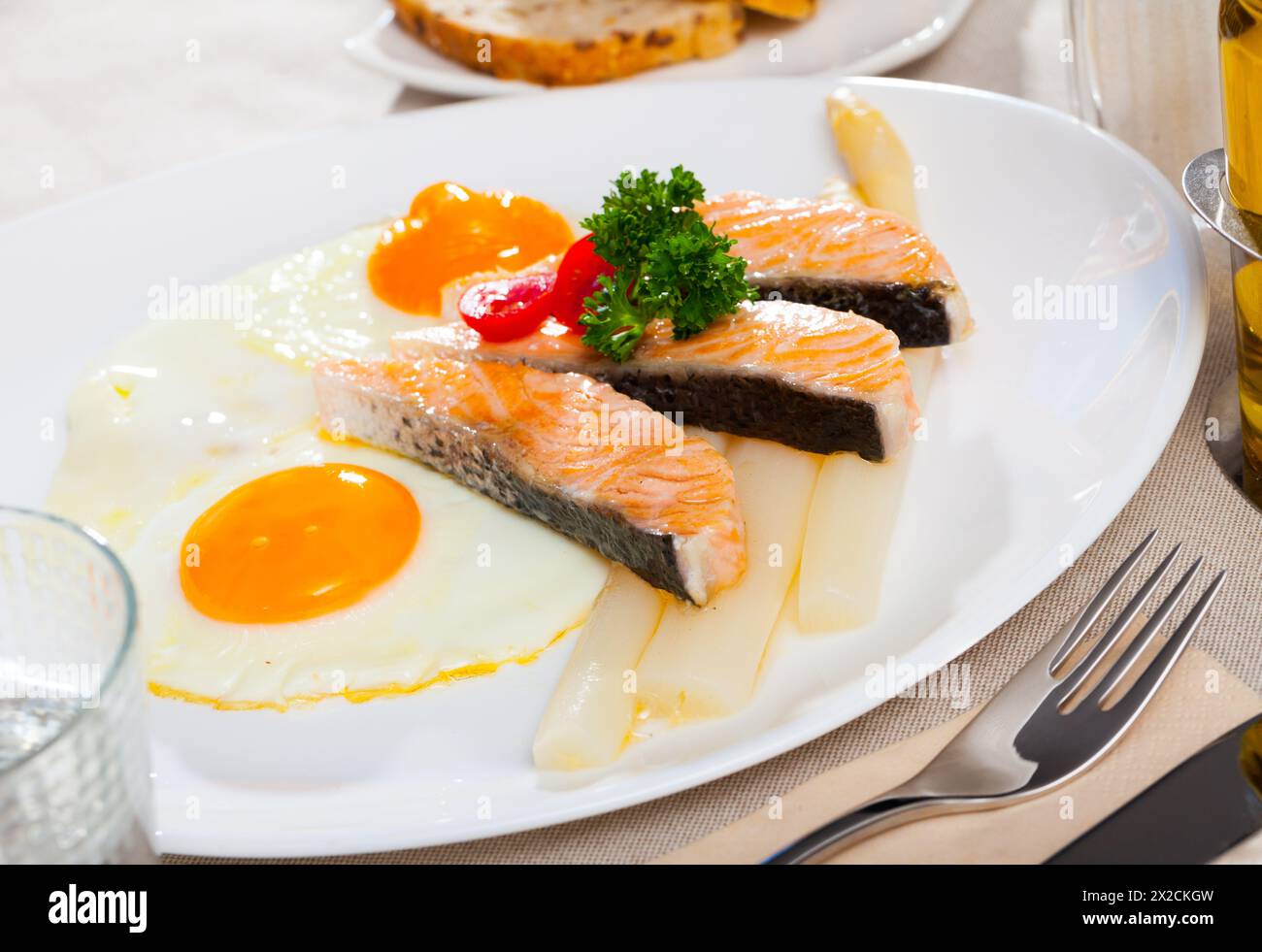 Fried salmon with scrambled eggs and asparagus Stock Photo