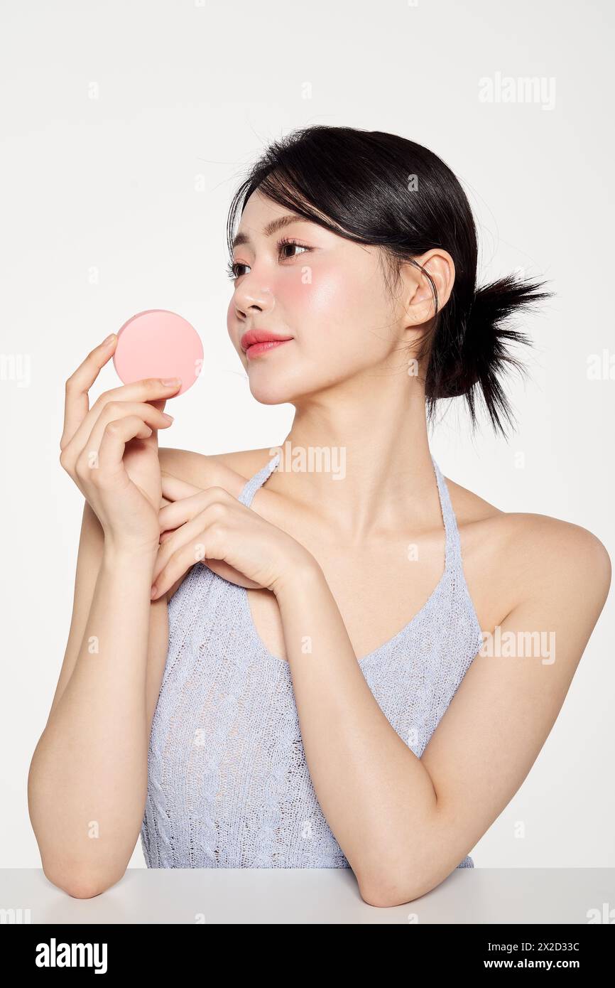 Asian woman with pink cushion pact turned her head Stock Photo