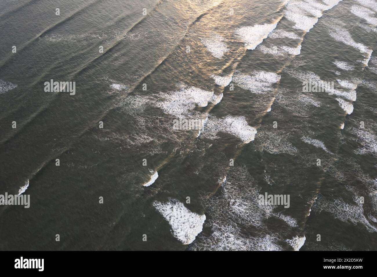 Breaking sea waves on ocean surface on sunset light aerial drone view Stock Photo