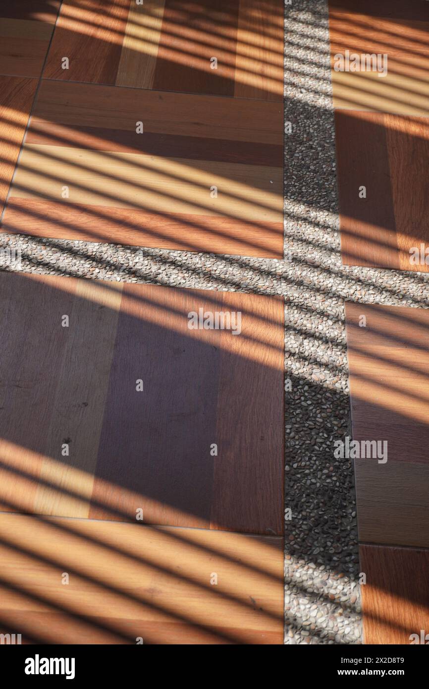 Shadows of oblique lines that hit the surface of the brown tiles with white lines in the afternoon Stock Photo