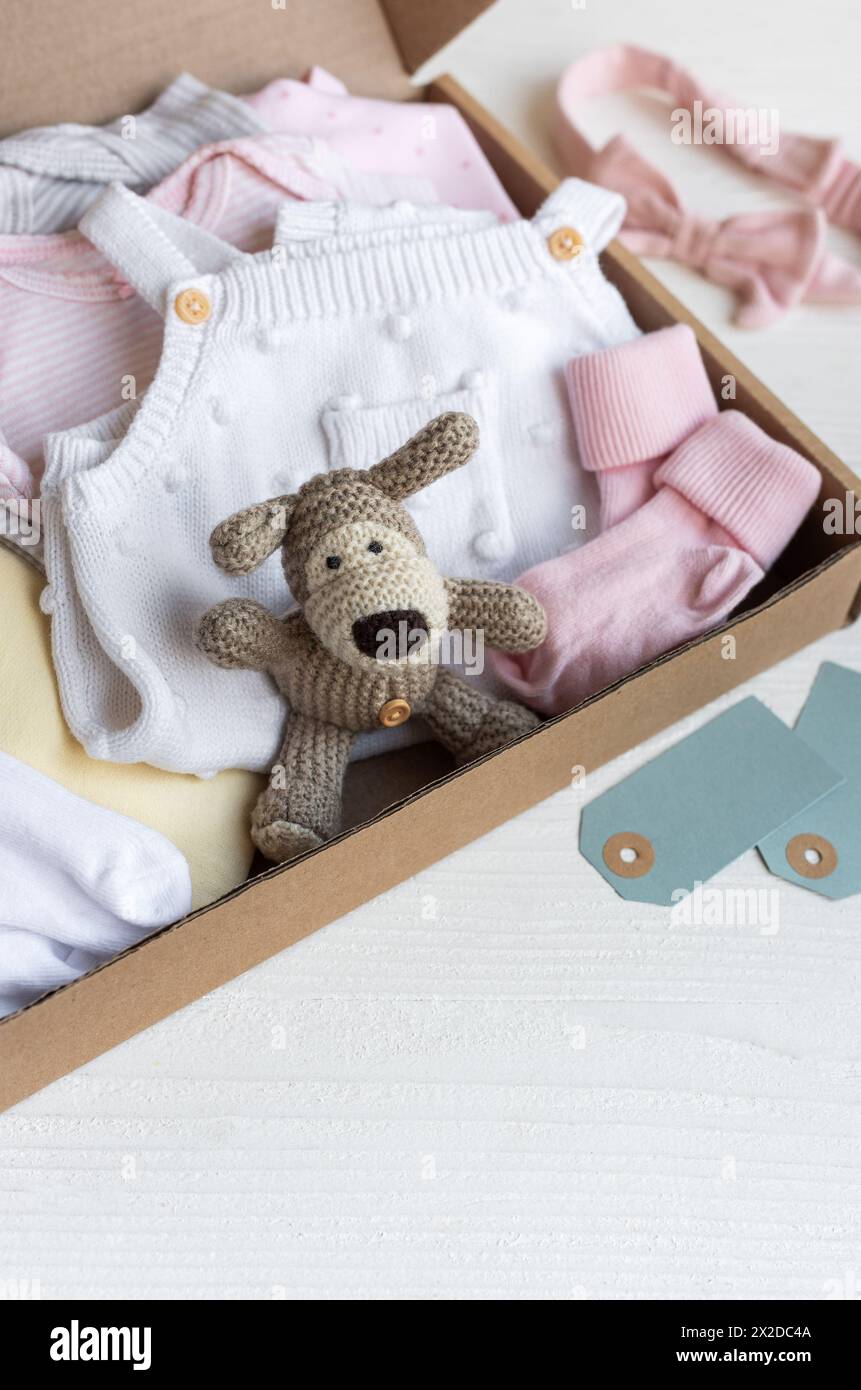 Baby and child clothes and knitted toys in carton box. Donation