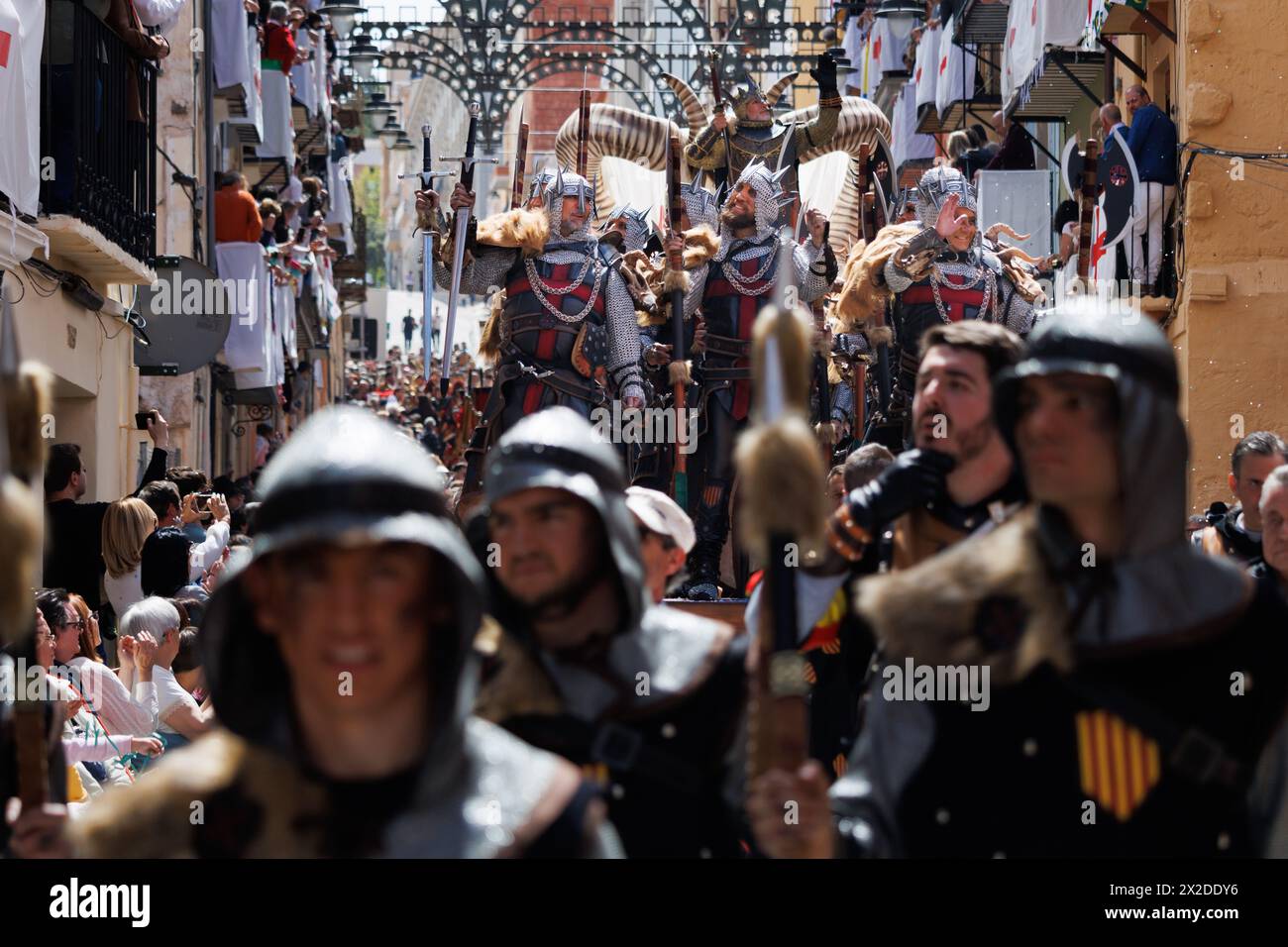 04-20-2024, Alcoy, Spain: Members of the Aragoneses troupe and in the background the Christian ensing with his knights on the float. Popular festivals Stock Photo