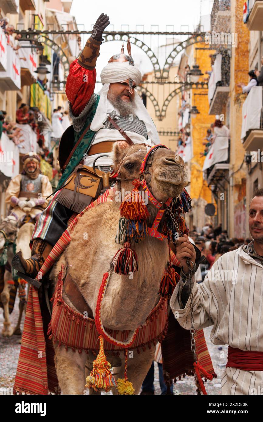 04-20-2024, Alcoy, Spain: Gentleman accompanying a dromedary from the Mudejares troupe parading through the streets of Alcoy Stock Photo