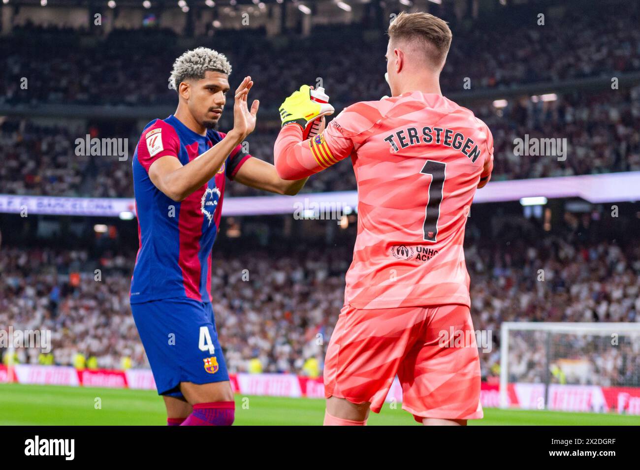 Madrid, Spain. 21st Apr, 2024. Ronald Araujo of FC Barcelona (L) seen cheering Marc Andre Ter Stegen of FC Barcelona (R) during the La Liga EA Sports 2023/24 football match between Real Madrid vs FC Barcelona at Estadio Santiago Bernabeu. Real Madrid 3 : 2 FC Barcelona Credit: SOPA Images Limited/Alamy Live News Stock Photo